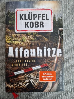 gebrauchtes Buch – Klüpfel, Volker; Kobr, Michael – Affenhitze (Kluftinger-Krimis 12) - Kluftingers neuer Fall | Kluftinger trifft auf Urzeitaffe »Udo«: Der Ausgrabungsort des berühmten Skeletts wird zum Tatort