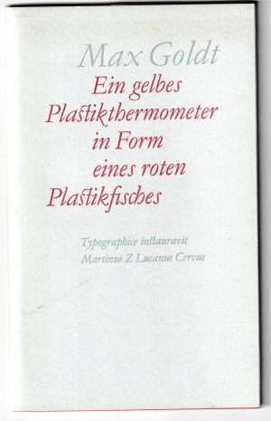 Ein gelbes Plastikthermometer in Form eines roten Plastikfisches - Typographisch angeordnet