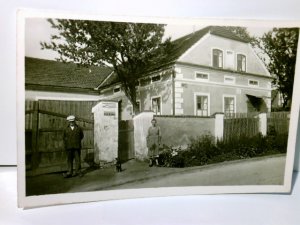 Unbekanntes Haus. Unbekannter Ort. Alte Ansichtskarte / Postkarte s/w, ungel. ca 30ger Jahre ?. Schild an Mauer : Ohm Krüger u. LLOYD Sudetenformat. Haus mit Gartenmauer, 2 Personen u. Hund am Tor.