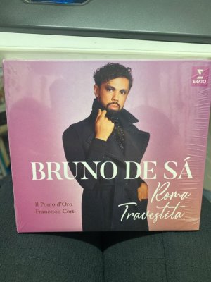 Roma Travestita „Was meine Stimme mir erlaubt“: Debütalbum Roma Travestita des Sopranisten Bruno de Sá  „Verblüffend… mit einem hohen Register von der Reinheit eines Soprans“, beschrieb das britische Opernmagazin Opera den jungen brasilianischen Sopranisten Bruno de Sá. Die Stimme des „Besten Nachwuchskünstlers“ (Oper! Awards 2020) ist weltweit beinahe einzigartig: Anders als Countertenöre erreicht de Sá die hohen Töne nicht durch Falsetttechnik, sie sind die natürliche Stimmlage des Sopranisten. Mit seinem vollen und farbenreichen Klang kommt er damit dem nahe, wie einst Kastratenstars wie Farinelli geklungen haben mögen. Dem Repertoire jener ersten Stimmvirtuosen widmet Bruno de Sá nun sein bei Erato erscheinendes Debütalbum Roma Travestita.  Der Titel des Albums ist eine Anspielung darauf, dass die Kastraten neben Heldenpartien auch Frauenrollen verkörperten. Gerade auf die Vielfalt der weiblichen Charaktere konzentriert sich Bruno de Sá bei der Arienauswahl: „Mein Ziel ist zu singe